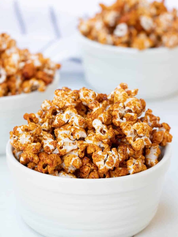 honey caramel corn, browned and looking like its full of flavor in three white bowls