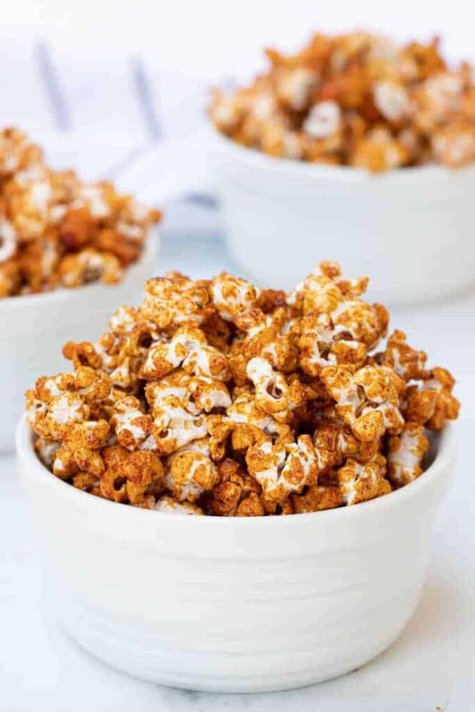 honey caramel corn, browned and looking like its full of flavor in three white bowls