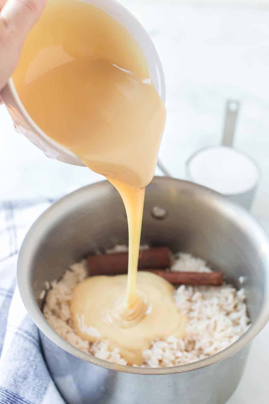 rice in medium sauce pan with cinnamon sticks and condensed milk