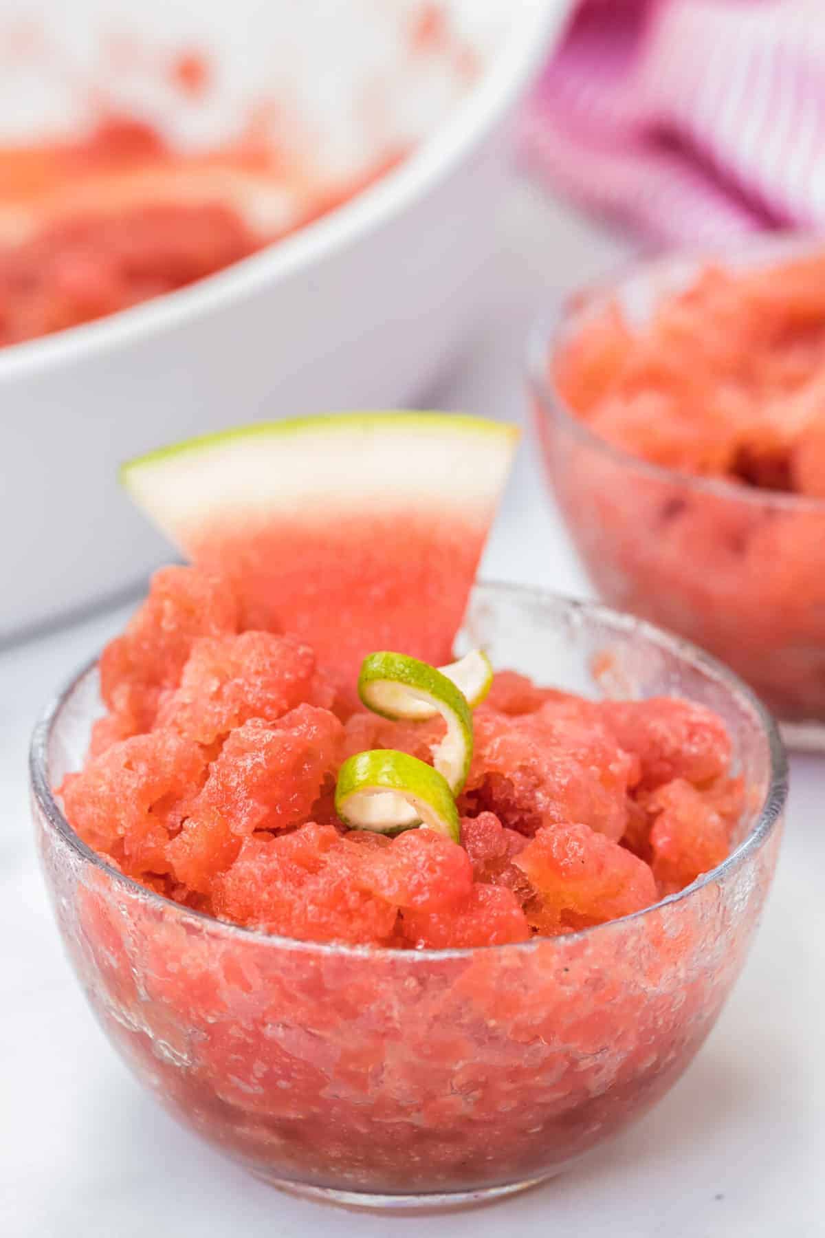 watermelon granita in a clear dish with a lime twist