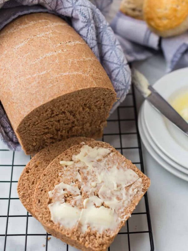 whole wheat bread on a cooling rack with butter