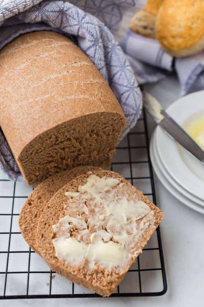 whole wheat bread on a cooling rack with butter