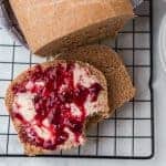 whole wheat bread on a cooling rack with butter and jam