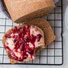 whole wheat bread on a cooling rack with butter and jam