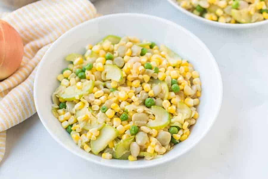 Zucchini and fresh corn succotash is a light and bright side dish that comes together easily and quickly with onion, zucchini, corn, and lima beans (plus a little hot sauce, if you like it)! #succotash #zucchinisuccotash #succotashrecipe #simplesuccotash #southerncooking #southernsides