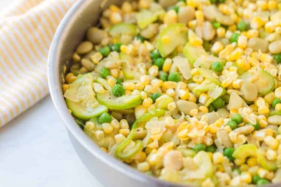 Zucchini and fresh corn succotash is a light and bright side dish that comes together easily and quickly with onion, zucchini, corn, and lima beans (plus a little hot sauce, if you like it)! #succotash #zucchinisuccotash #succotashrecipe #simplesuccotash #southerncooking #southernsides