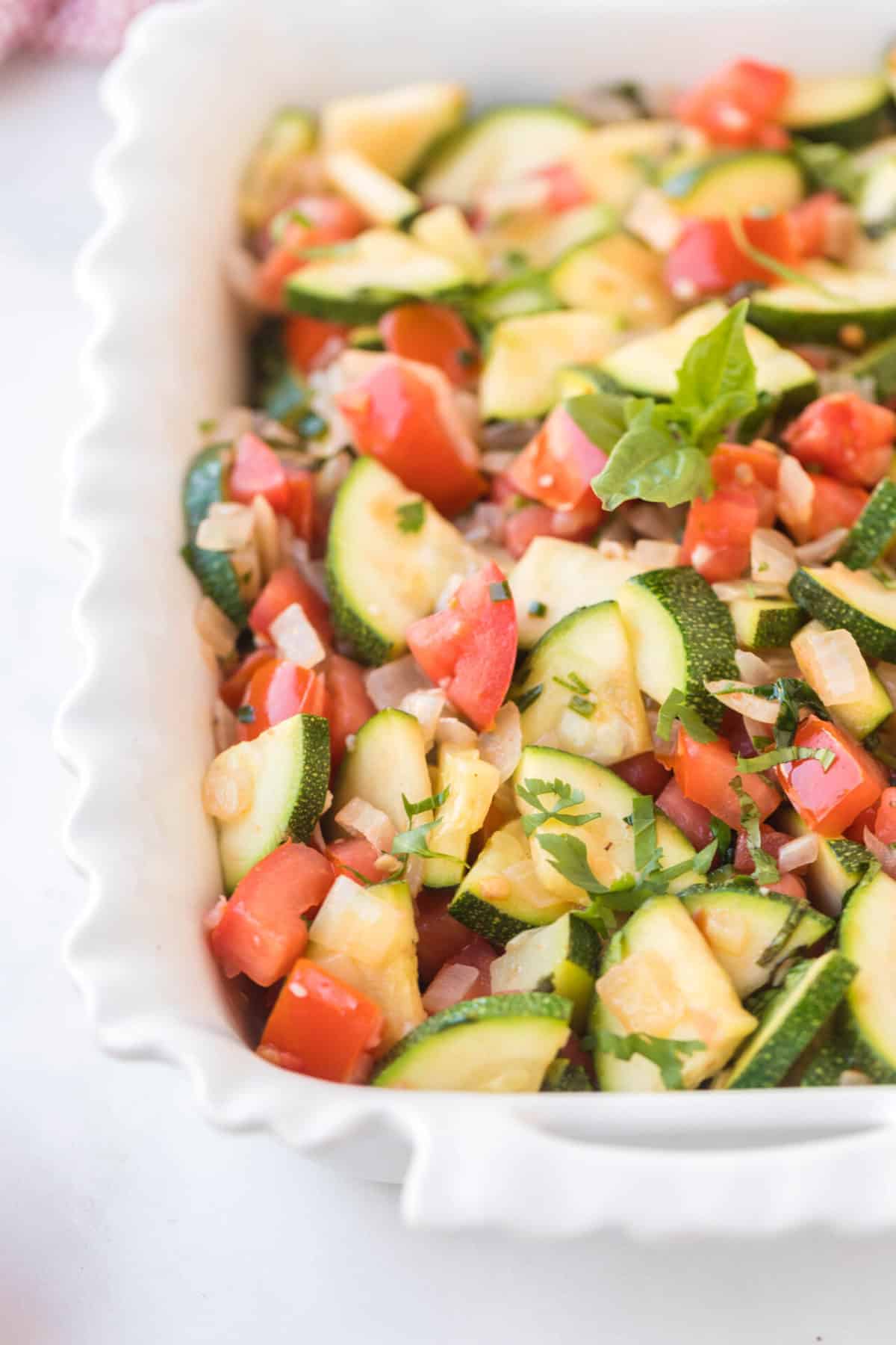 zucchini and tomato side dish in a baking pan.