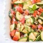 zucchini and tomato in a baking pan for a side dish with zucchini recipe.