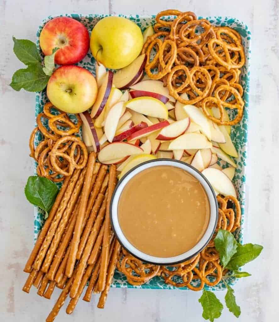 top view of apples and pretzels laid around a bowl of homemade caramel dip