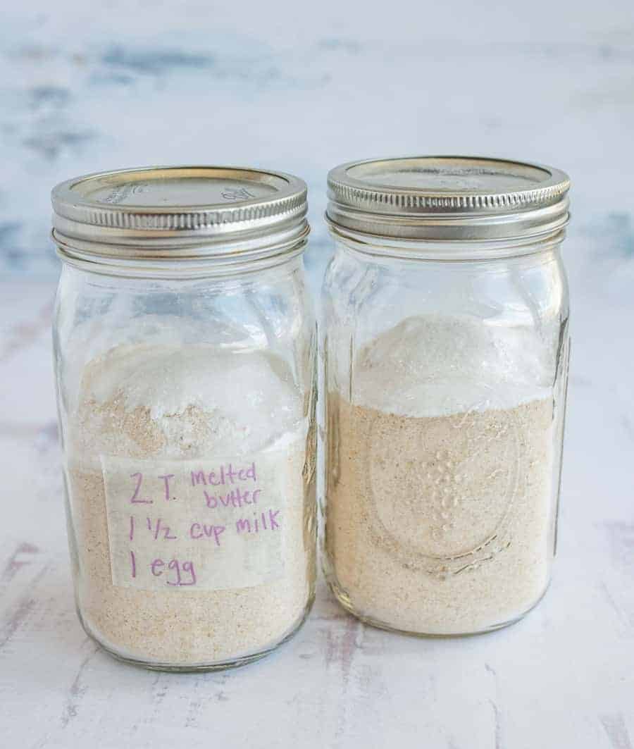 two clear mason jars with metal lids, dry powdered ingredients inside, and tape attached.