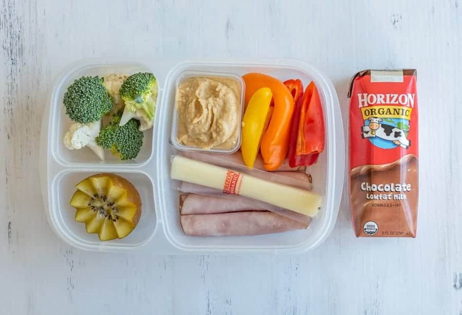 tupperware with compartments for different lunch ingredients and chocolate milk on the side.