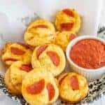 pizza bites with marinara dipping on parchment in a bowl