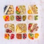 lots of different tupperware with lunch items separated in compartments.