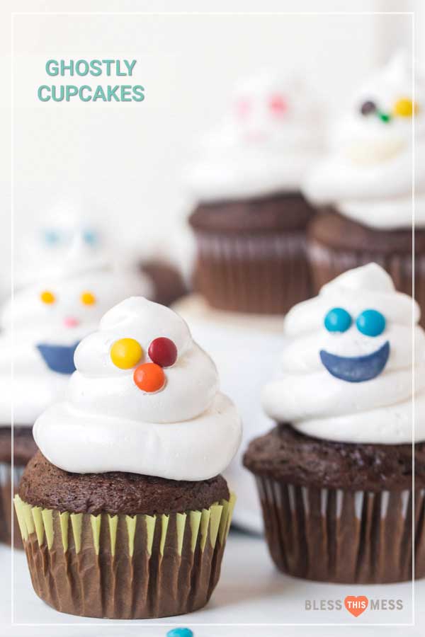 Chocolate cupcakes with white frosting and colorful candy faces
