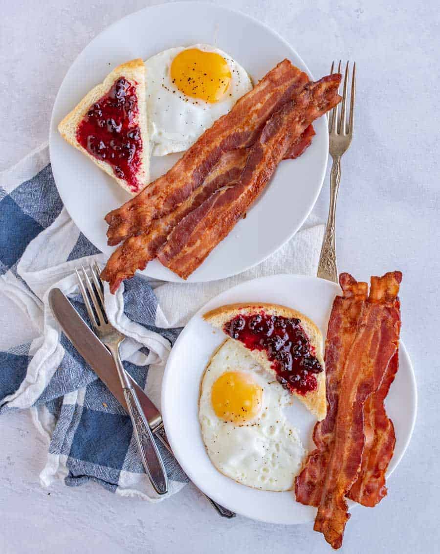 Baking bacon in the oven is the simplest way to make a large or small amount of crispy bacon -- with minimal cleanup! This easy bacon recipe comes out perfect every time. Anyone can make perfect bacon every time with this easy-to-follow oven recipe! #bacon #ovenbacon #bakedbacon #easybacon #baconrecipe #howtomakebacon