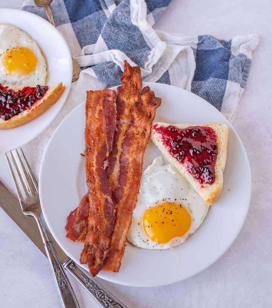 Baking bacon in the oven is the simplest way to make a large or small amount of crispy bacon -- with minimal cleanup! This easy bacon recipe comes out perfect every time. Anyone can make perfect bacon every time with this easy-to-follow oven recipe! #bacon #ovenbacon #bakedbacon #easybacon #baconrecipe #howtomakebacon