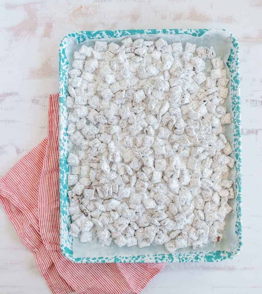 Puppy chow with peanut butter, chocolate, Chex, and powdered sugar is one of the most fun sweet treats ever, and it comes together quickly for a crunchy dessert, easy goody bag, or delicious after-school snack! This homemade puppy chow recipe is one of the simplest and most fun treats to make. I love getting the kids involved because it's so straightforward and a great way to get them interested in cooking and baking! #puppychowrecipe #puppychow #muddybuddies #chexcereal #simpledesserts