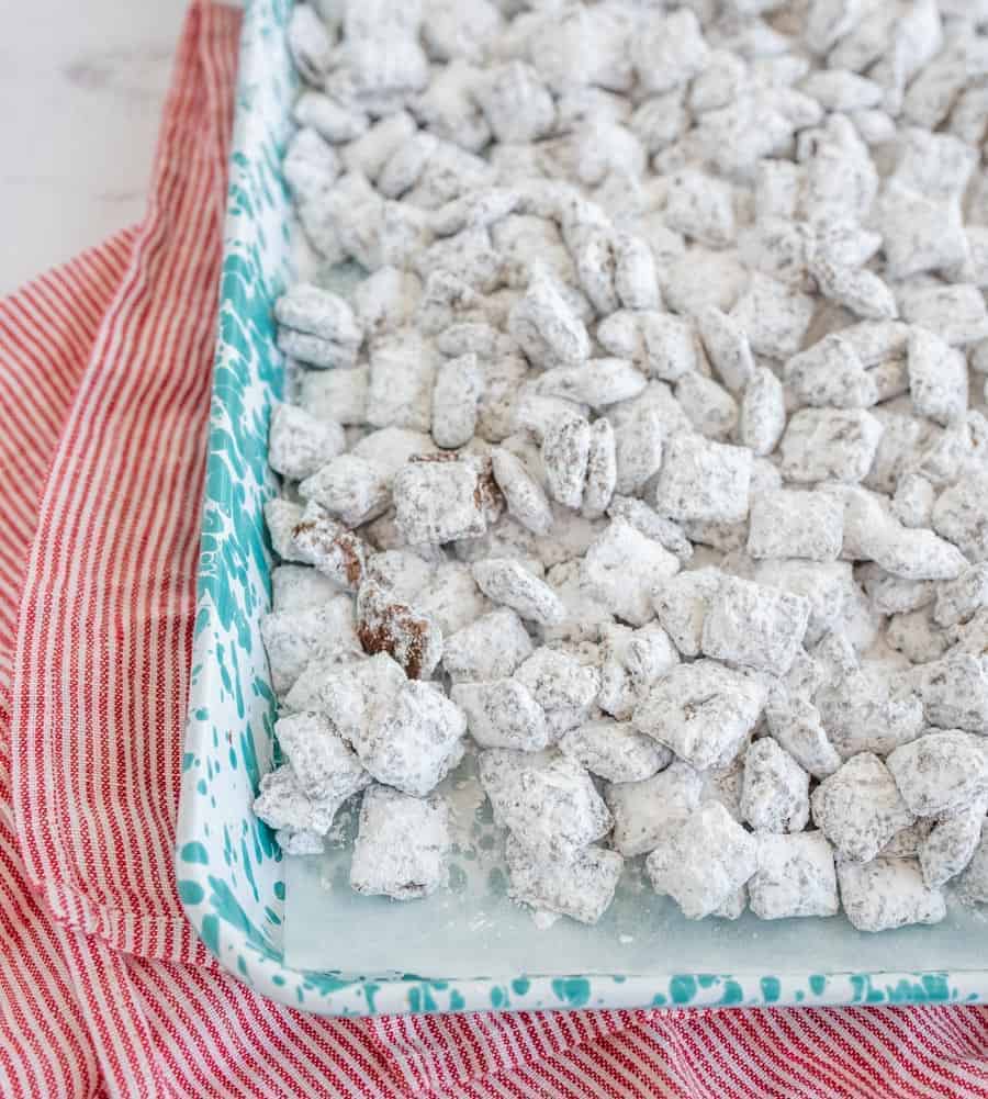 Puppy chow with peanut butter, chocolate, Chex, and powdered sugar is one of the most fun sweet treats ever, and it comes together quickly for a crunchy dessert, easy goody bag, or delicious after-school snack! This homemade puppy chow recipe is one of the simplest and most fun treats to make. I love getting the kids involved because it's so straightforward and a great way to get them interested in cooking and baking! #puppychowrecipe #puppychow #muddybuddies #chexcereal #simpledesserts