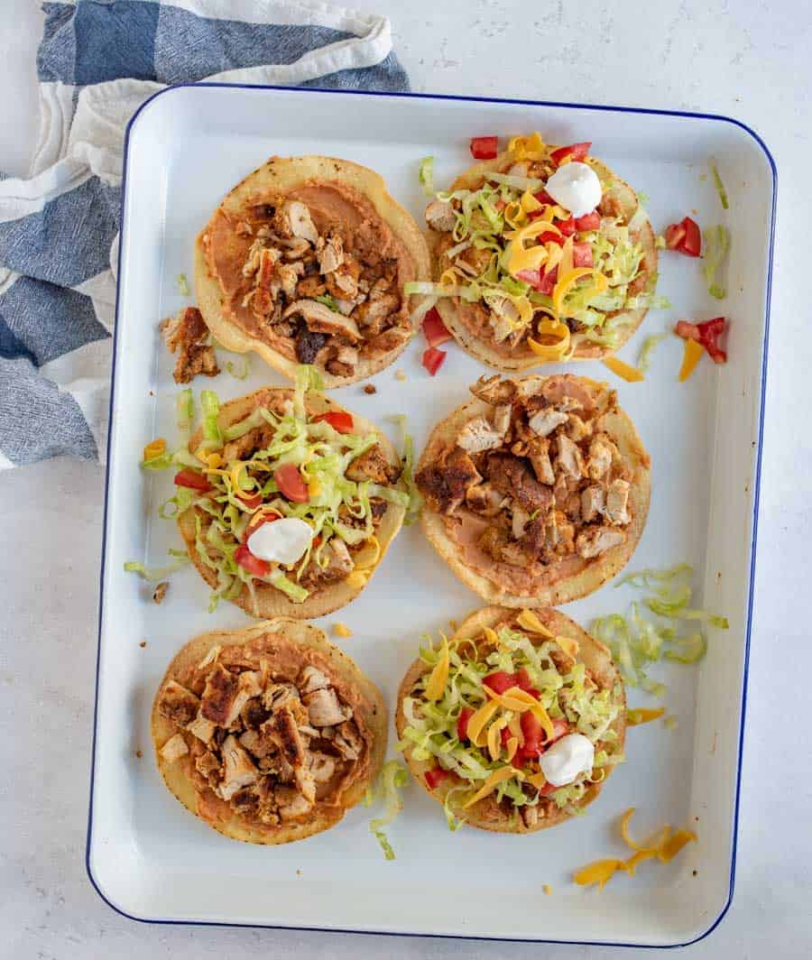 The best chicken tostadas take only 30 minutes to make, including simple baked tostada shells, and the whole family will love them. They come together quickly and they're bursting with flavor, which is kind of the best thing ever when it comes to weeknight meals. #tostadas #chickentostadas #tacos #texmex #mexicanfood #tostadarecipe