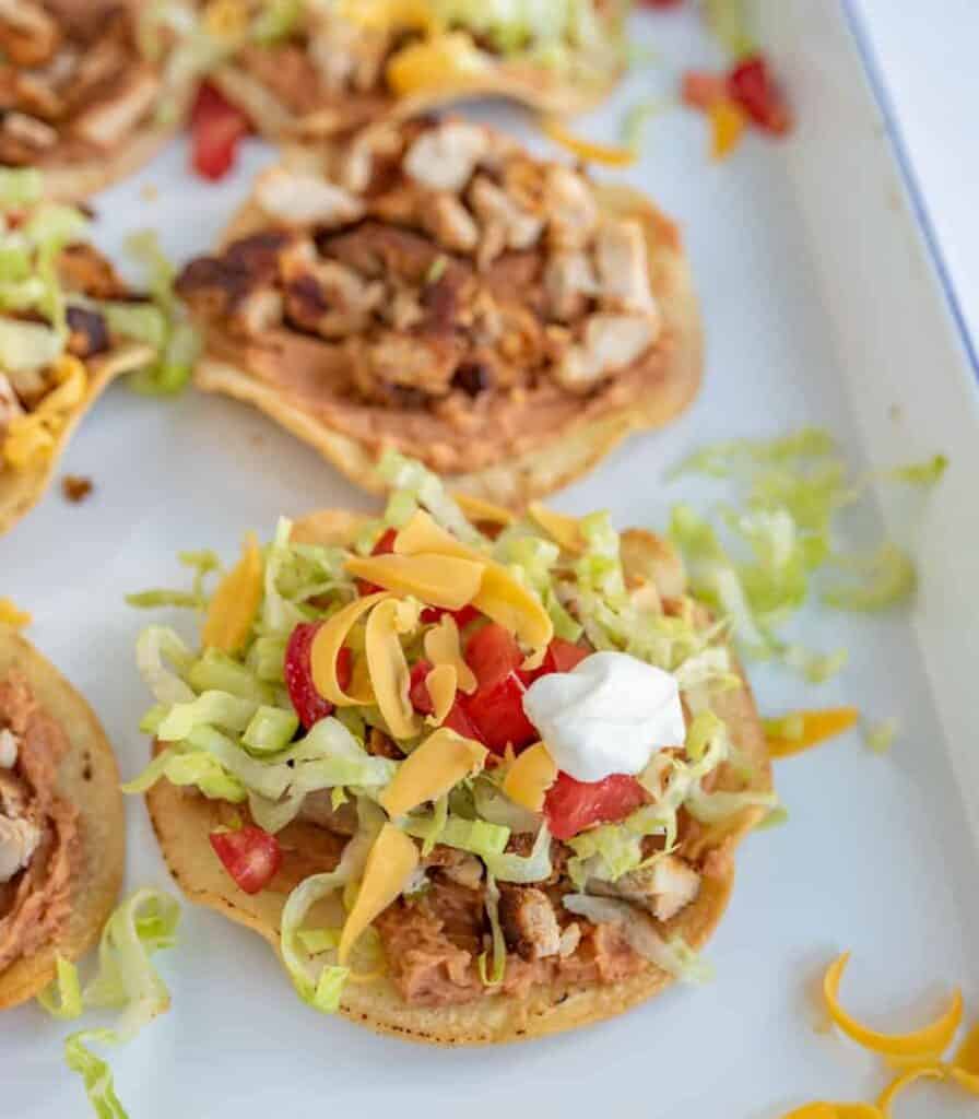 close up of chicken tostada on white plate