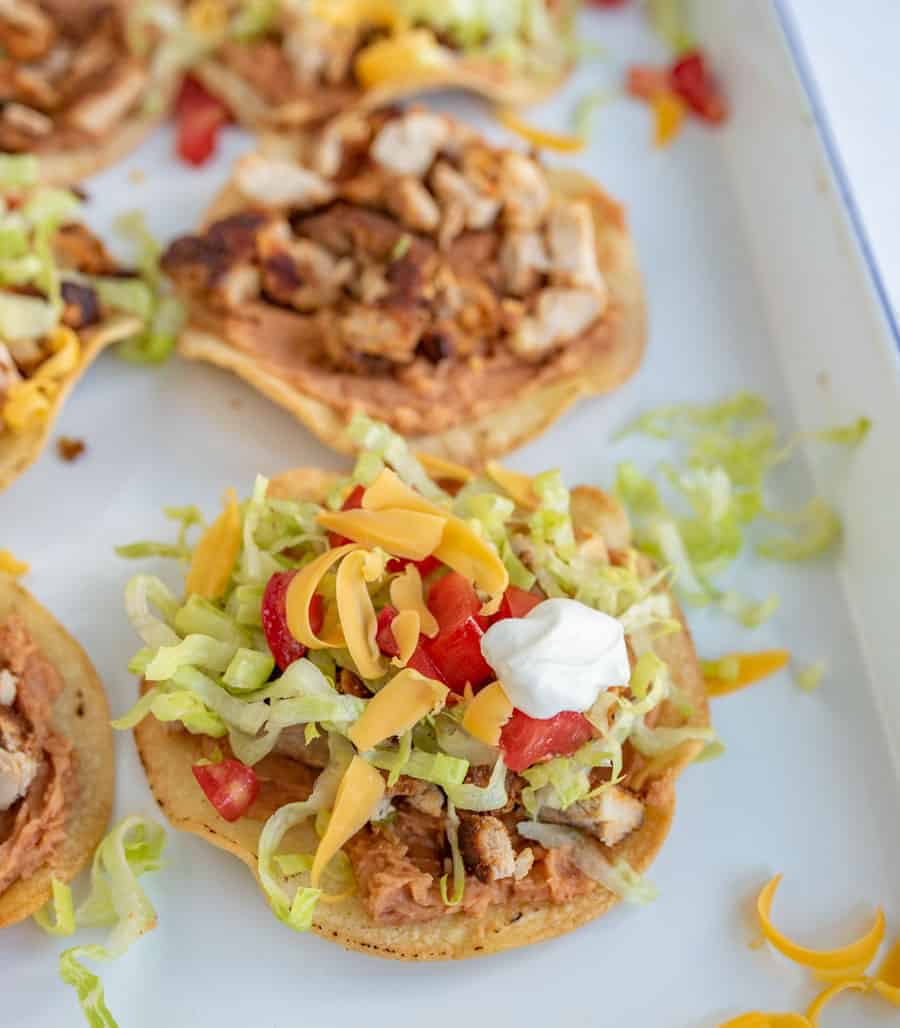 The best chicken tostadas take only 30 minutes to make, including simple baked tostada shells, and the whole family will love them. They come together quickly and they're bursting with flavor, which is kind of the best thing ever when it comes to weeknight meals. #tostadas #chickentostadas #tacos #texmex #mexicanfood #tostadarecipe