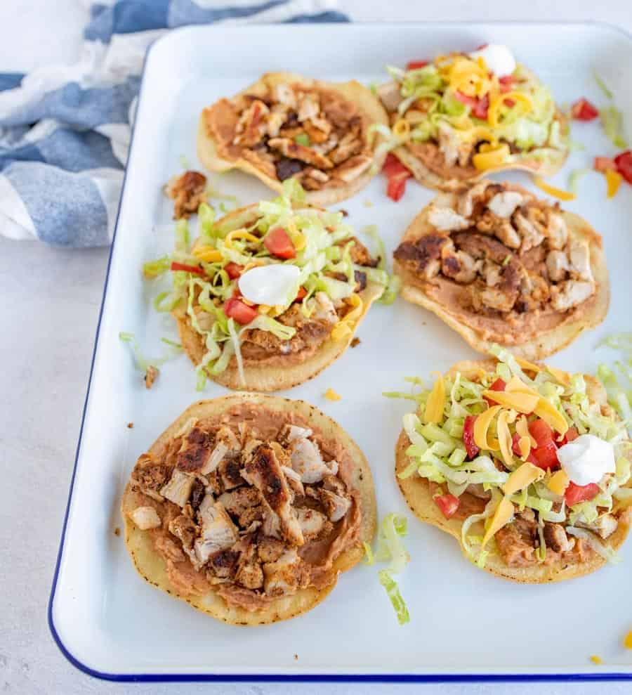 The best chicken tostadas take only 30 minutes to make, including simple baked tostada shells, and the whole family will love them. They come together quickly and they're bursting with flavor, which is kind of the best thing ever when it comes to weeknight meals. #tostadas #chickentostadas #tacos #texmex #mexicanfood #tostadarecipe