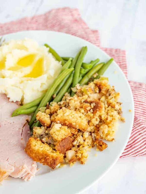ham mashed potatoes green beans and stuffing on a white plate