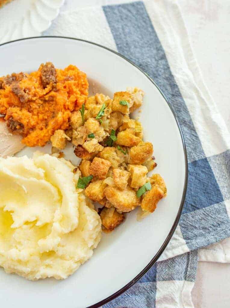 mashed potatoes stuffing and sweet mashed potatoes on a white plate