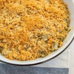 a circular baking dish with crispy onions on top a traditional green bean caserole