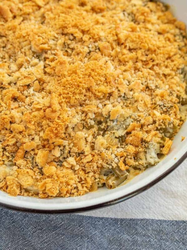 a circular baking dish with crispy onions on top a traditional green bean caserole