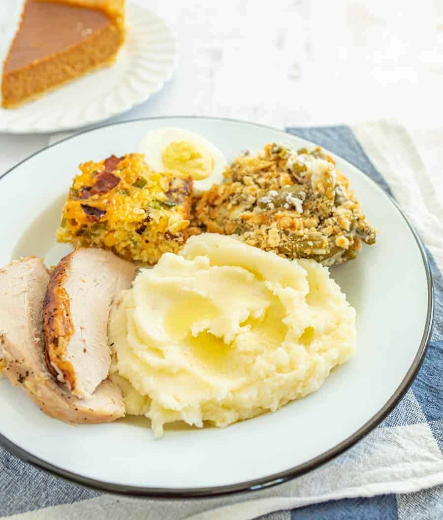 green bean casserole mashed potatoes turkey on round white plate