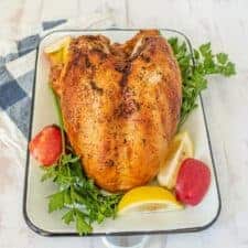 Whole roasted turkey on rectangular white dish