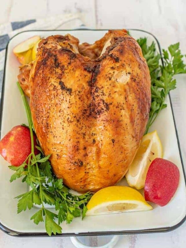 Whole roasted turkey on rectangular white dish