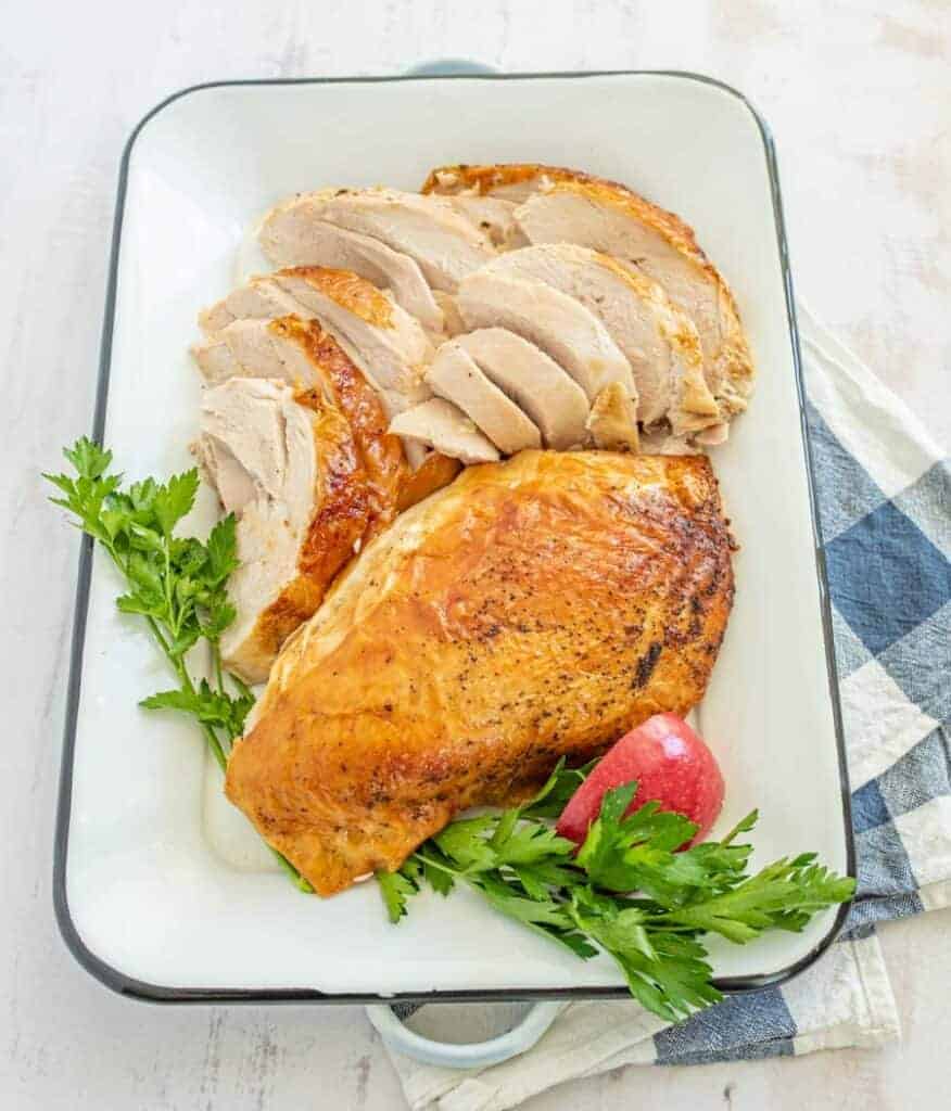 Roasted turkey on a large rectangular dish half cut and half whole