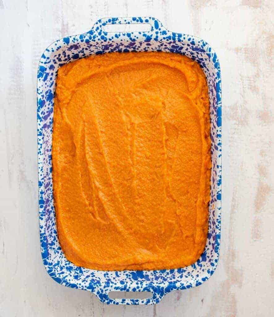 sweet potato casserole in a white and blue pan.