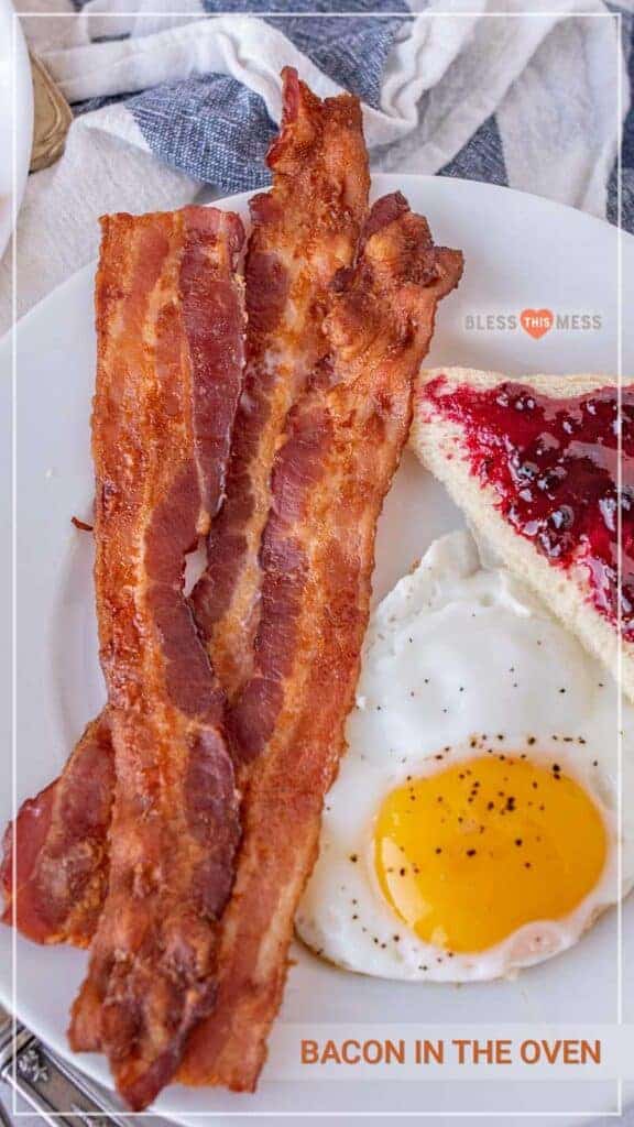 three slices of bacon an egg and some toast with jelly