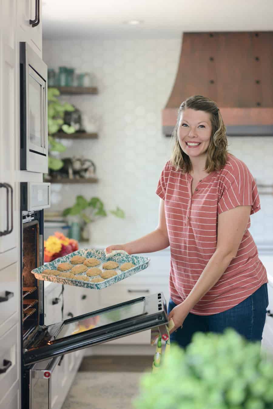 woman putting cookies in the oven