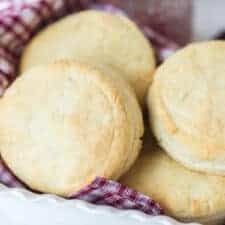 cream biscuits on red checked towel in white dish