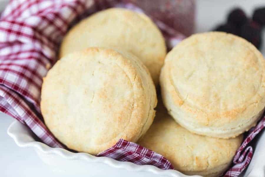 simple cream biscuits wrapped in red and white checked towel in white dish