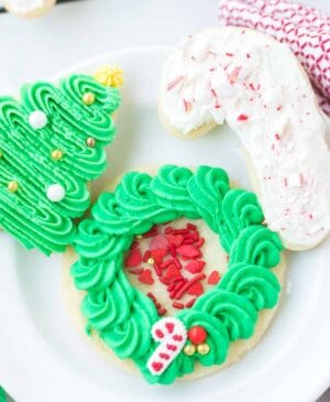 iced sugar cookies on a white plate decorated in holiday style