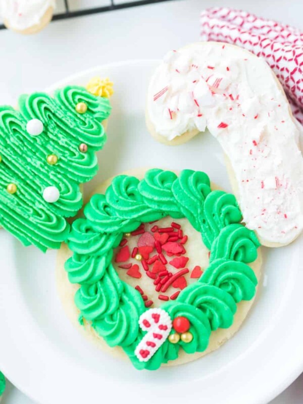 iced sugar cookies on a white plate decorated in holiday style