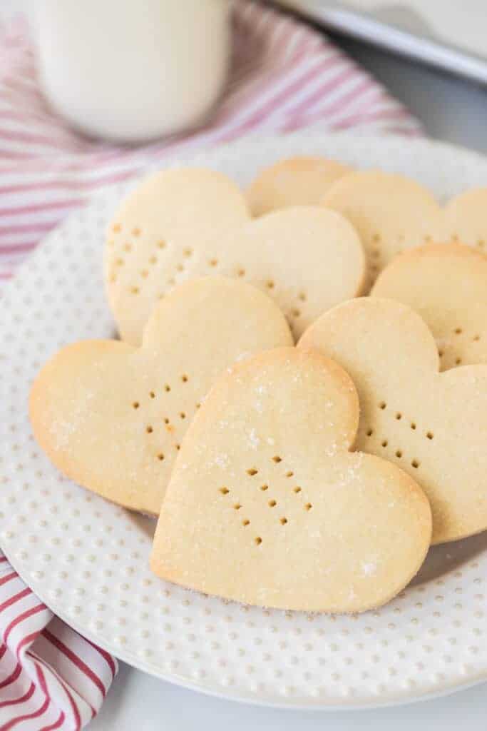 heart shaped shortbread cookies with fork punctures on a white plate
