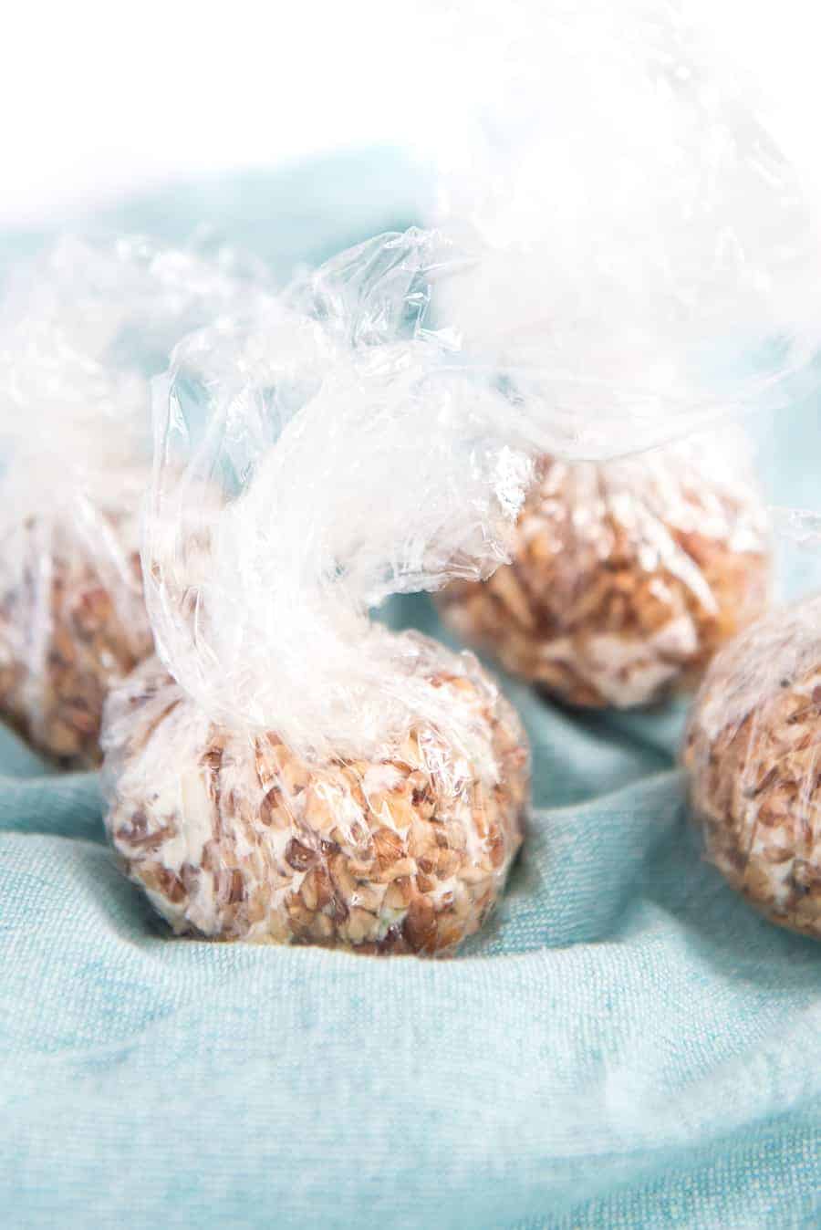 A blue cloth with beef and onion cheese balls wrapped in plastic wrap