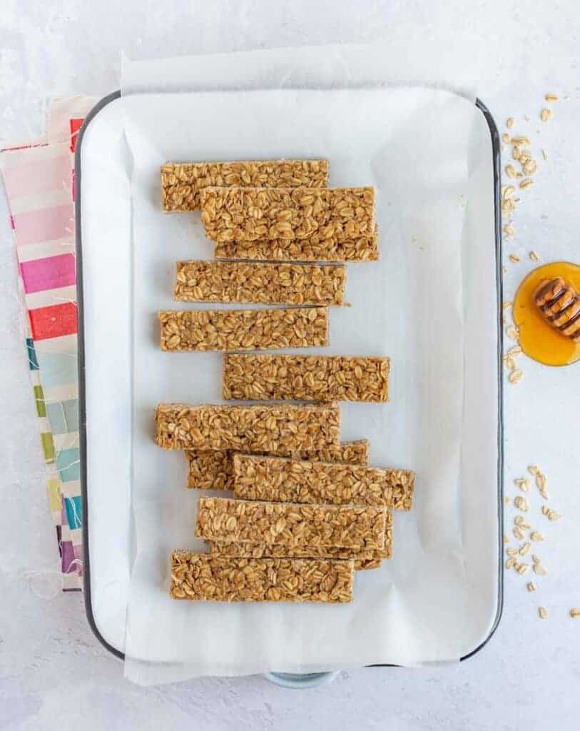 homemade granola bars in a parchment-lined white rectangular pan