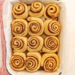 baked cinnamon rolls lined into a pan uniced