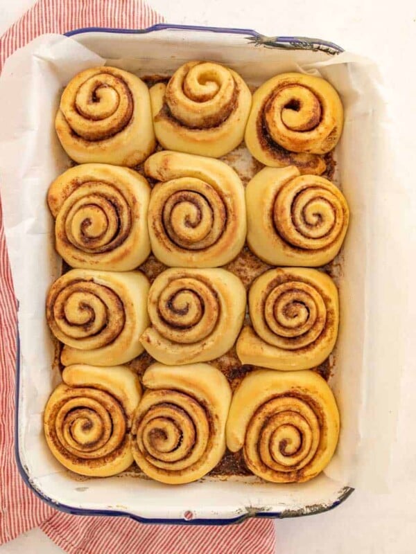 baked cinnamon rolls lined into a pan uniced