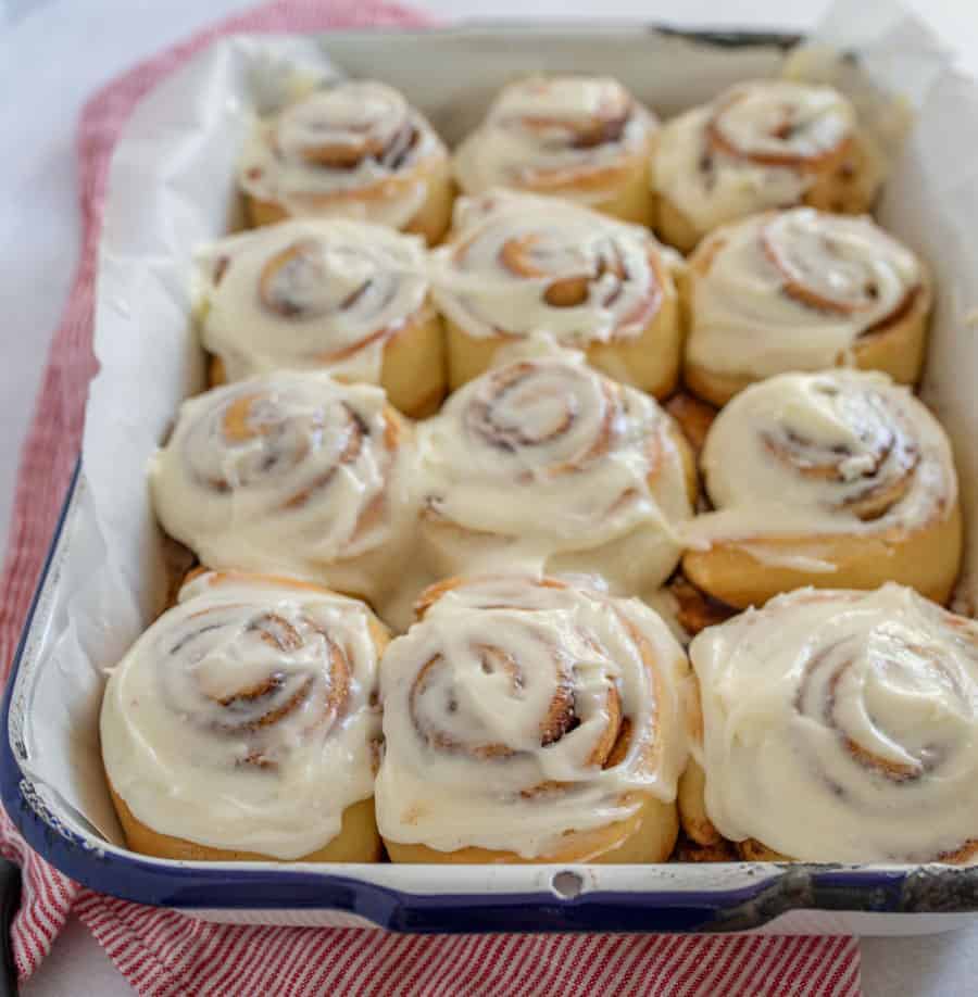 A closeup of the finished cinnamon rolls covered in frosting.