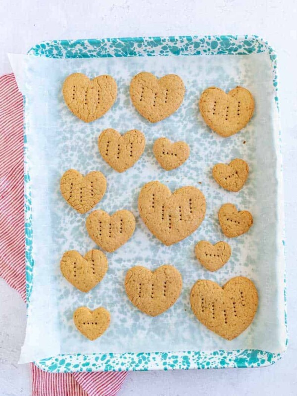 graham crackers in the shape of little hearts with fork punctures in them on a stack on a plate