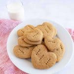 graham crackers in the shape of little hearts with fork punctures in them on a stack on a plate