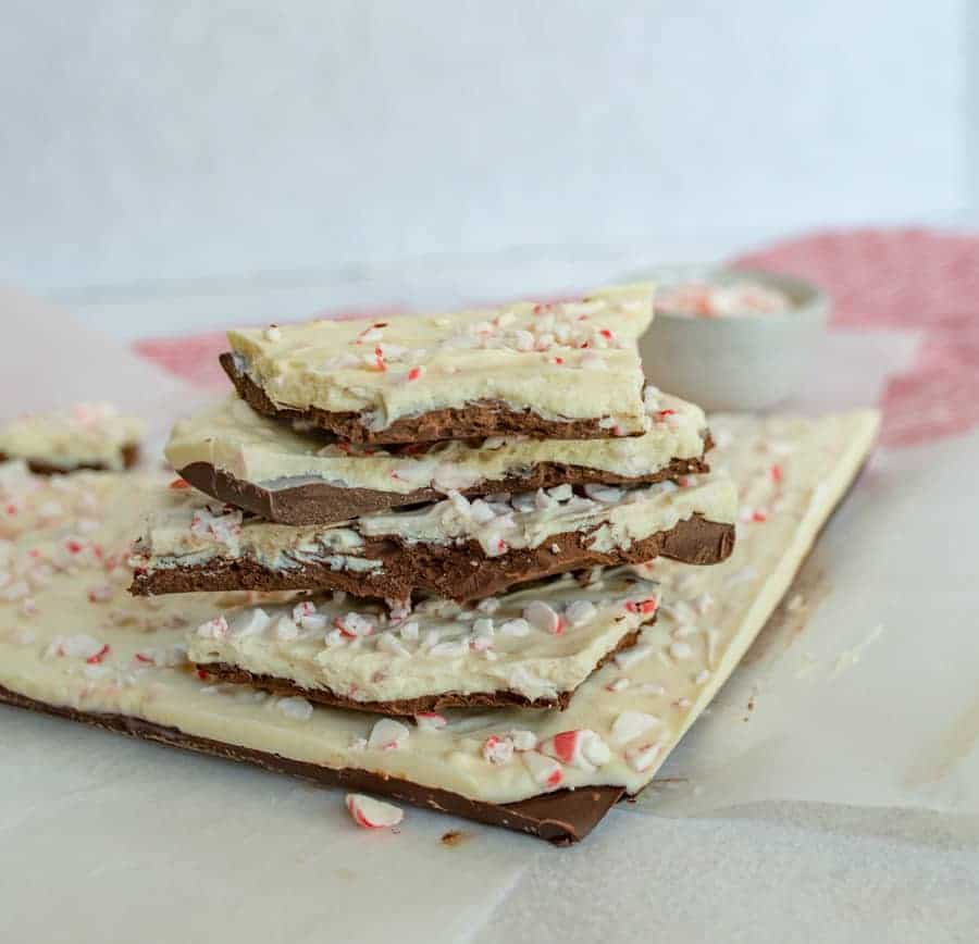 A large piece of peppermint bark with smaller pieces stacked on top of it.